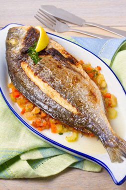 Bütün kılıçbalığı veya dorada balık sebze, kekik ve limon, dikey