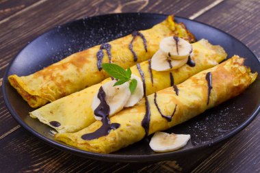 Ev yapımı krep muz, çikolata ve nane ile servis tatlı beyaz peynir dolu. Kaydırılan krep