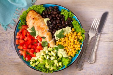 Tavuk yemeği besleyici sebzeler yelpazesi ile: avokado, fasulye, domates ve tatlı mısır. Tavuk göğsü salatası