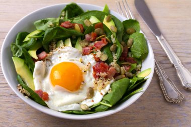 Sahanda yumurta pastırma, quinoa, avokado, ıspanak ve kahvaltı için kabak çekirdeği