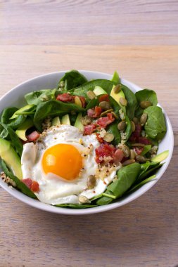 Sahanda yumurta pastırma, quinoa, avokado, ıspanak ve kahvaltı için kabak çekirdeği