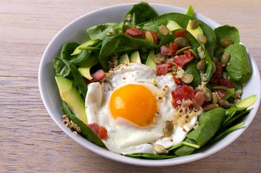 Sahanda yumurta pastırma, quinoa, avokado, ıspanak ve kahvaltı için kabak çekirdeği