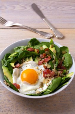 Sahanda yumurta pastırma, quinoa, avokado, ıspanak ve kahvaltı için kabak çekirdeği