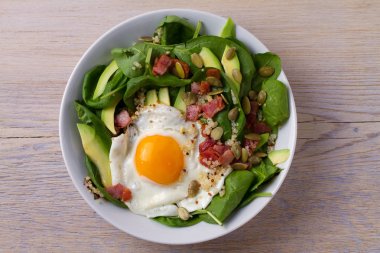 Sahanda yumurta pastırma, quinoa, avokado, ıspanak ve kahvaltı için kabak çekirdeği