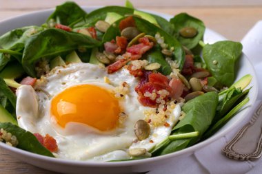 Sahanda yumurta pastırma, quinoa, avokado, ıspanak ve kahvaltı için kabak çekirdeği