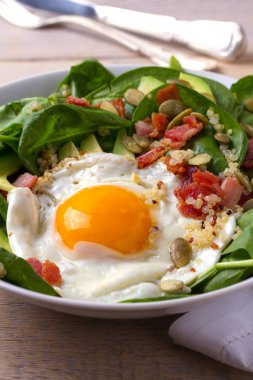Sahanda yumurta pastırma, quinoa, avokado, ıspanak ve kahvaltı için kabak çekirdeği