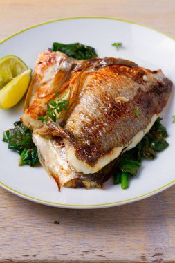 Dorado veya dorada balık fileto ıspanak, kekik ve limon, dikey