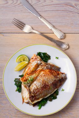 Dorado veya dorada balık fileto ıspanak, kekik ve limon ile. Yukarıdan görüntülemek, top, dikey