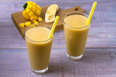 Mango muz smoothie ahşap arka plan, yatay