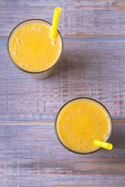 Mango muz smoothie ahşap arka plan üzerinde. Yukarıdan görüntülemek, top, dikey