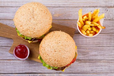Ev yapımı hamburger ve patates ahşap arka plan üzerinde. Yukarıdan görüntülemek, top, yatay