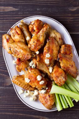 Buffalo kanatları ahşap arka plan üzerinde beyaz tabakta tavuk