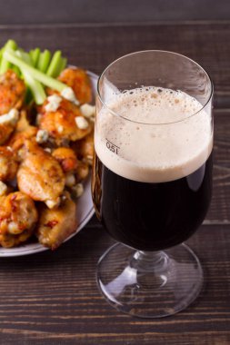 Bardak koyu bira ve siracha tavuk tavuk kanadı. Ale ve gıda