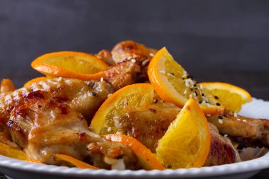 Tatlı ve ekşi tavuk kanadı ile portakal, hizmet ile susam beyaz plaka üzerinde