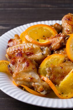 Tatlı ve ekşi tavuk kanadı ile portakal, hizmet ile susam beyaz plaka üzerinde