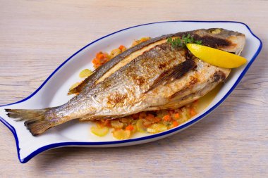 Havuç, soğan ve kereviz saplarını üzerinde ızgara çupra