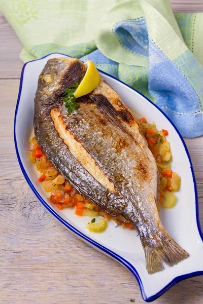 Havuç, soğan ve kereviz saplarını üzerinde ızgara çupra