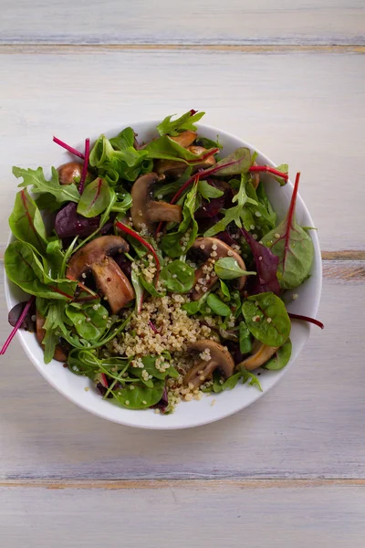 Quinoa salad with mushrooms, herbs, spinach, arugula. Quinoa healthy superfood concept. Clean healthy detox eating. Vegan and vegetarian food. View from above, top