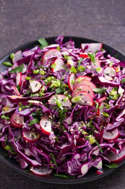 Kırmızı lahana, turp, soğan, maydanoz ve susam tohumu salata. Vejetaryen salata sağlıklı gıda kavramı. dikey