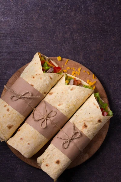 Sığır eti, domates, marul, salatalık, peynir ve Mısır kesme tahtası üzerinde ile tamamladı. Tortilla, burrito, bükülmüş sandviç rulo. 