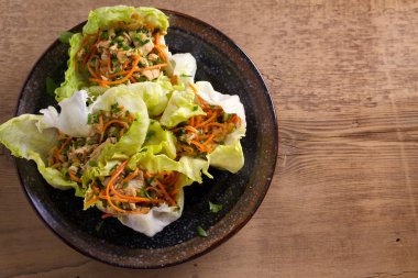 Marul, tavuk, havuç, fıstık ve yeşil soğan ile tamamladı. Marul dolması Tavuk ile bırakır. Yukarıdan görüntülemek, top 