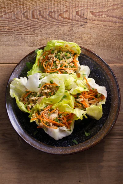 Lettuce wraps with chicken, carrot, peanuts and scallion. Stuffed iceberg lettuce leaves with chicken. View from above, top