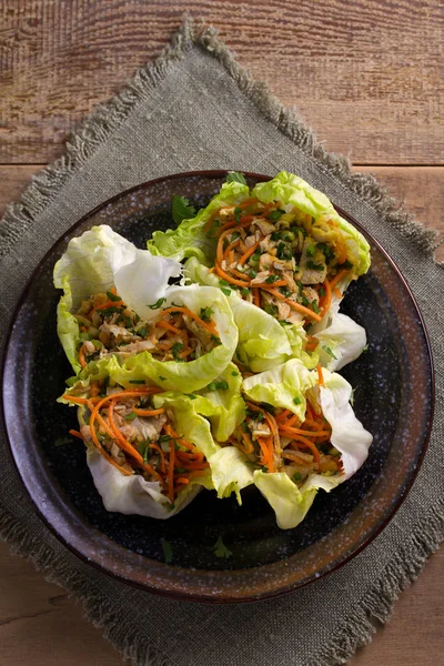 Lettuce wraps with chicken, carrot, peanuts and scallion. Stuffed iceberg lettuce leaves with chicken. View from above, top