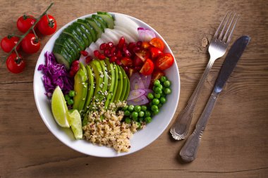 Yeme sağlıklı Detoks temiz. Vegan ve vejetaryen yemek kase. Quinoa, avokado, nar, domates, yeşil bezelye, turp ve kırmızı lahana salatası. Yukarıdan görüntülemek, top
