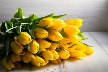 Buket bahar Lale çiçek Beyaz ahşap zemin üzerinde. Sarı laleler