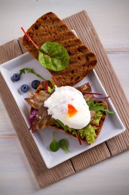 Yumurta, pastırma, ezilmiş beyaz fasulye ve avokado tost. Sandviç