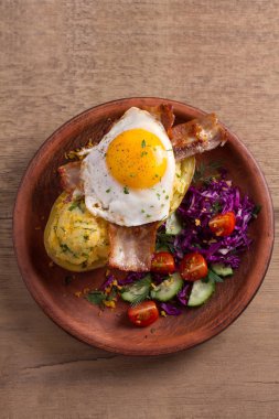 Ceketli fırında patates peynir ile yüklenen ve pastırma ile tepesinde ve sebze ile plaka üzerinde yumurta kızarmış. Tepesi ile doldurulmuş patates. Yukarıdan görüntülemek, top, ek yükü 