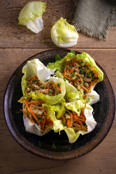 Stuffed iceberg lettuce cabbage leaves with chicken and vegetables. Wraps pockets of lettuce with chicken. overhead