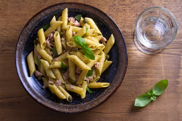 Tuna, basil and caper penne. Pasta with tuna fish. View from above, top studio shot