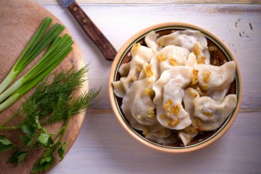 Pierogi veya pyrohy, varenyky, vareniki, ahşap masa ıslak zeminde köfte. Yatay