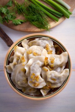 Pierogi veya pyrohy, varenyky, vareniki, ahşap masa ıslak zeminde köfte. dikey