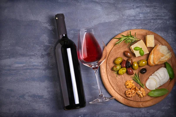 Bottle Glass Wine Cheese Olives Bread Nuts Basil Dark Background — Stock Photo, Image