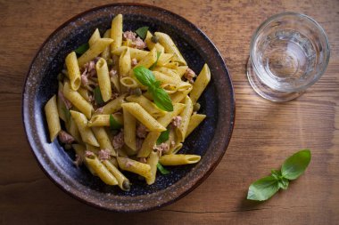 Ton balığı, fesleğen ve Kapari penne pesto sos kase ahşap arka plan ile. Ton balıklı makarna. Tepegöz, yatay