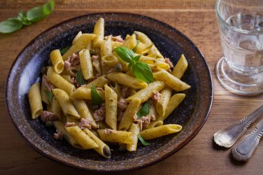 Ton balığı, fesleğen ve Kapari penne pesto sos kase ahşap arka plan ile. Ton balıklı makarna. Tepegöz, yatay