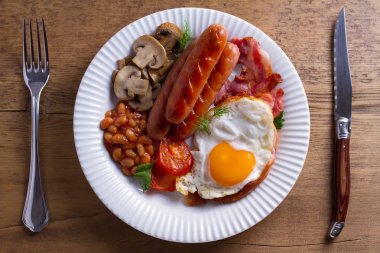 Tam İngilizce veya İrlandalı kahvaltı: sosis, pastırma, yumurta, mantar, domates ve fasulye. Besleyici sabah yemek