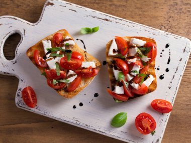 Caprese Bruschetta. Domates, fesleğen, mozzarella peyniri balsamik azaltma Çiseleme tost ile. Meze - starter çanak. Yukarıdan görüntülemek, top