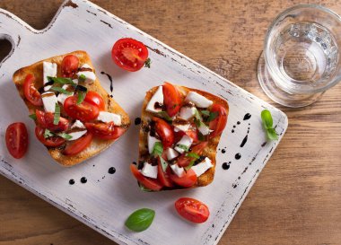 Caprese Bruschetta. Domates, fesleğen, mozzarella peyniri balsamik azaltma Çiseleme tost ile. Meze - starter çanak. Yukarıdan görüntülemek, top