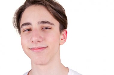 Yakışıklı genç çocuk kameraya bakıyor. Beyaz T-shirt genç closeup portresi. Mutlu erkek gülümseyen izole üzerinde beyaz arka plan