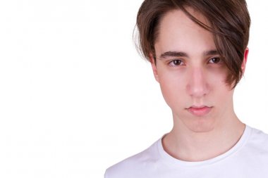 Yakışıklı genç çocuk kameraya bakıyor. Beyaz tişört, beyaz arka plan üzerinde izole genç closeup portresi