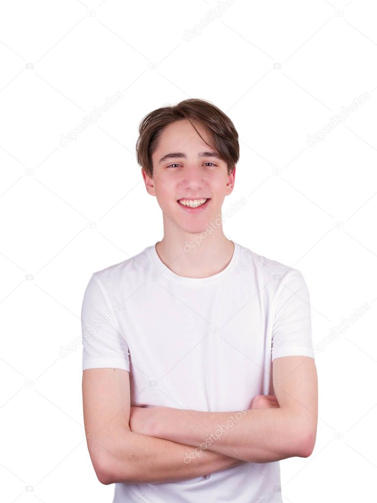 Handsome teen boy  looking at camera. Portrait of teenager in white T-shirt. Confident young man keeping arms crossed and smiling, isolated on white background
