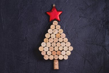 Siyah arka planda şarap mantarlarından yapılmış Noel ağacı. Düzen, düzlük, şablon. Yeni yıl kış tatili geçmişi
