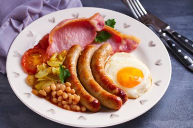 Sosis, pastırma, yumurta, domates, patates kızartması ve fasulye. yatay resim 