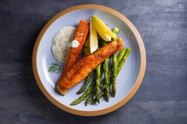 Kuşkonmaz ve kremalı sarımsak soslu somon balığı filetosu. Yukarıdan görüntüle, üstten