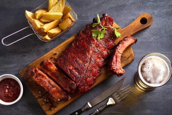 Varkenslende Ribbetjes Geserveerd Snijplank Aardappelpartjes Een Glas Bier Uitzicht Van — Stockfoto