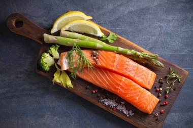 Taze çiğ somon fileto bifteği, sebze ve malzemelerle pişirmek için hazırlandı.