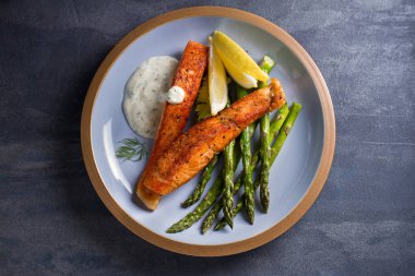 Kuşkonmaz ve limon dilimli lezzetli somon balığı filetoları.